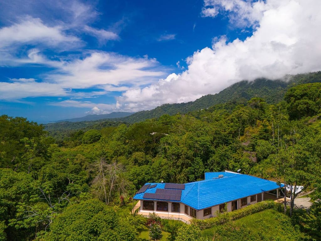Aerial view of Casa Rosa Blanca on its rainforest hillside with mountains behind, Ojochal, Costa Rica