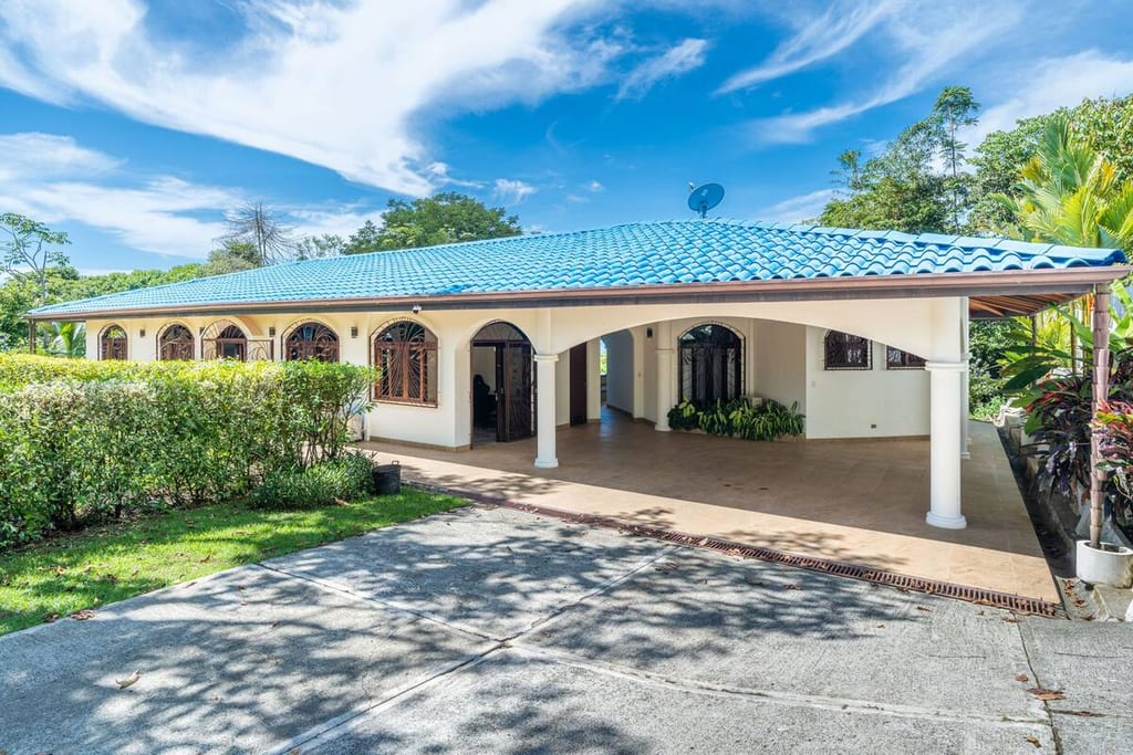 The covered carport and front entrance of Casa Rosa Blanca