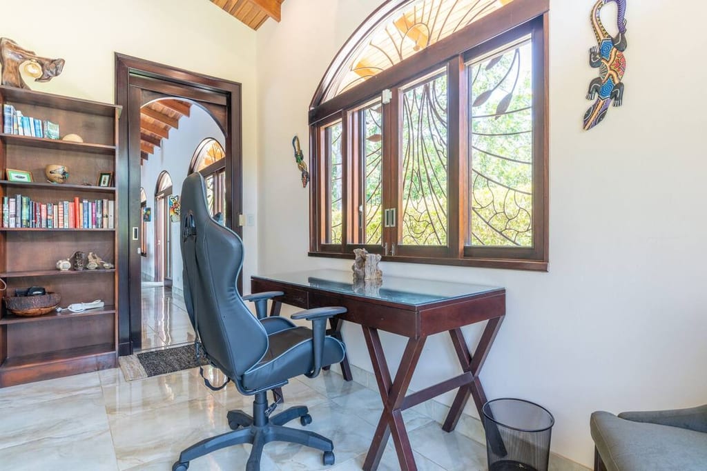 Writing desk beside stained glass windows looking into the rainforest