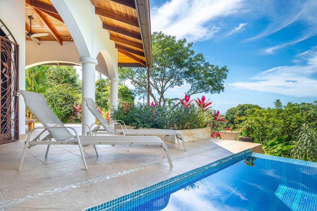 Sun loungers beside the infinity pool with ocean views