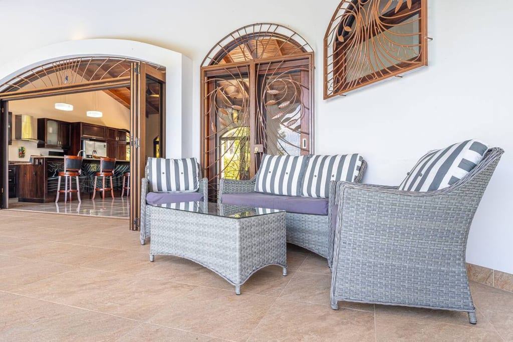 Outdoor lounge seating beside the bar under the villa's arches