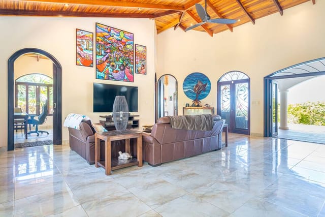 Living area with leather sofas, artwork and doors opening to the terrace