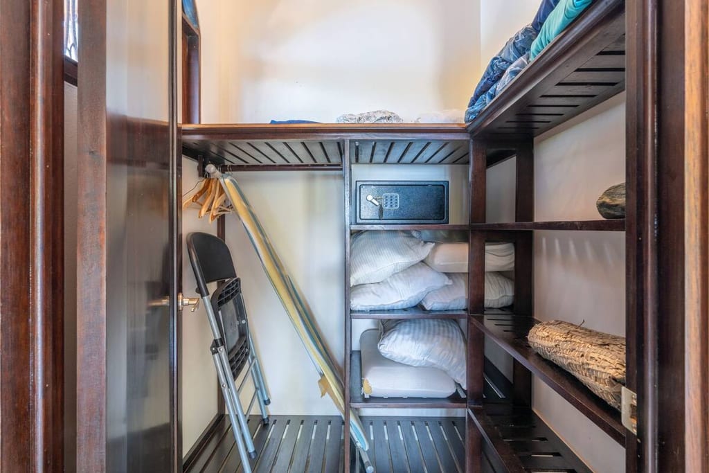 Linen storage with spare bedding, safe and folding beds