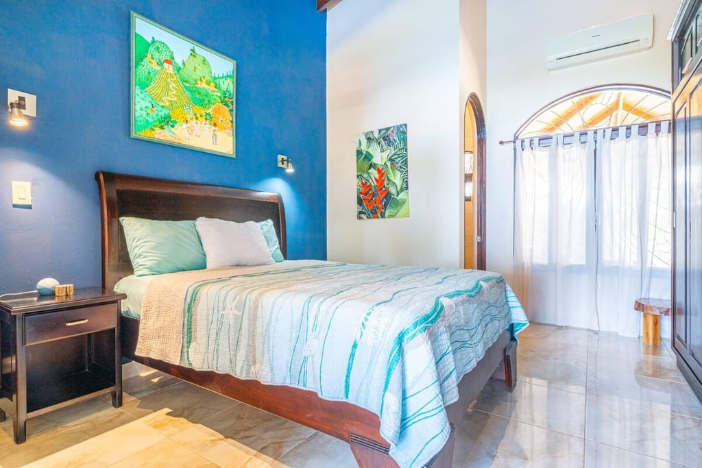 Ocean Room guest bedroom with queen bed, blue accent wall and air conditioning